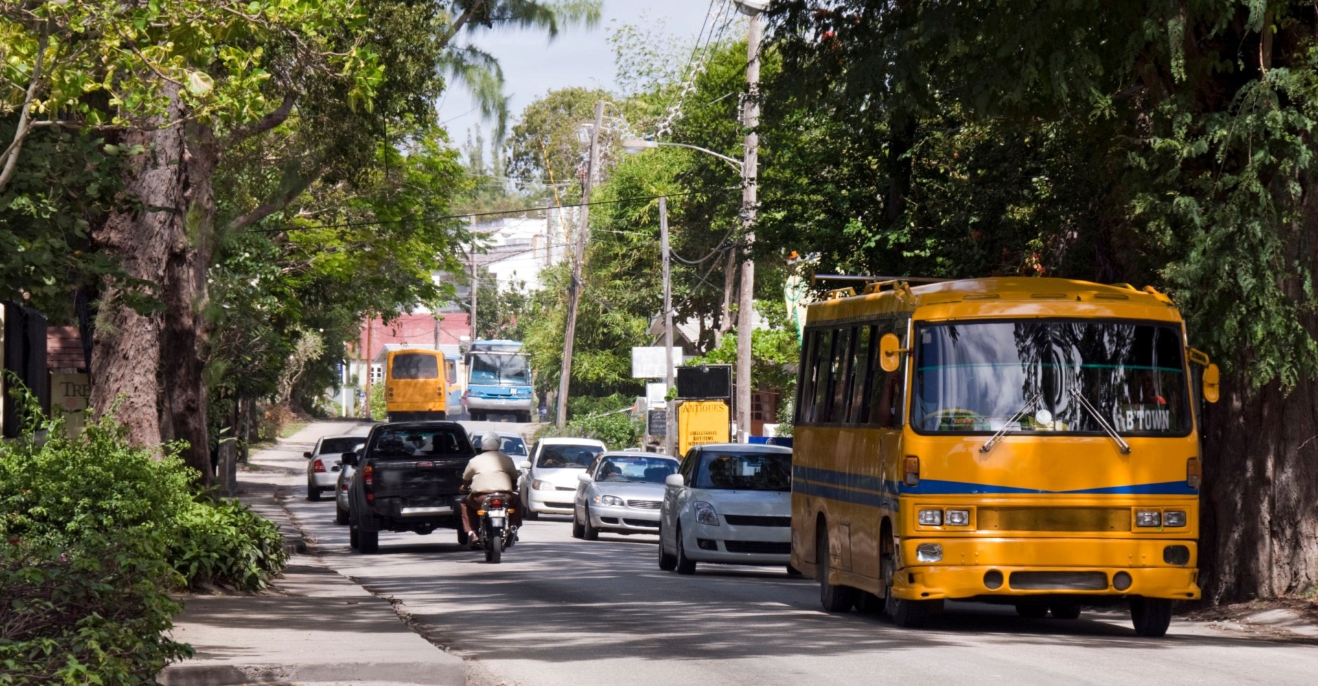 oncoming traffic including an orange bus on a roadway in Barbados 