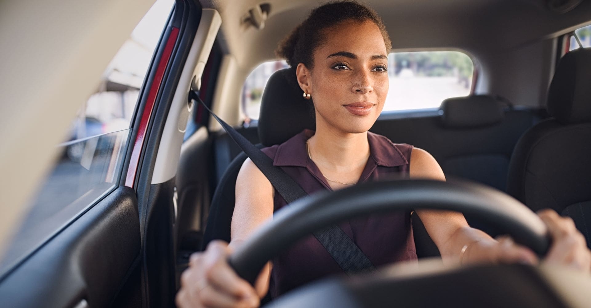 woman driving a car shot from the dashboard perspective 