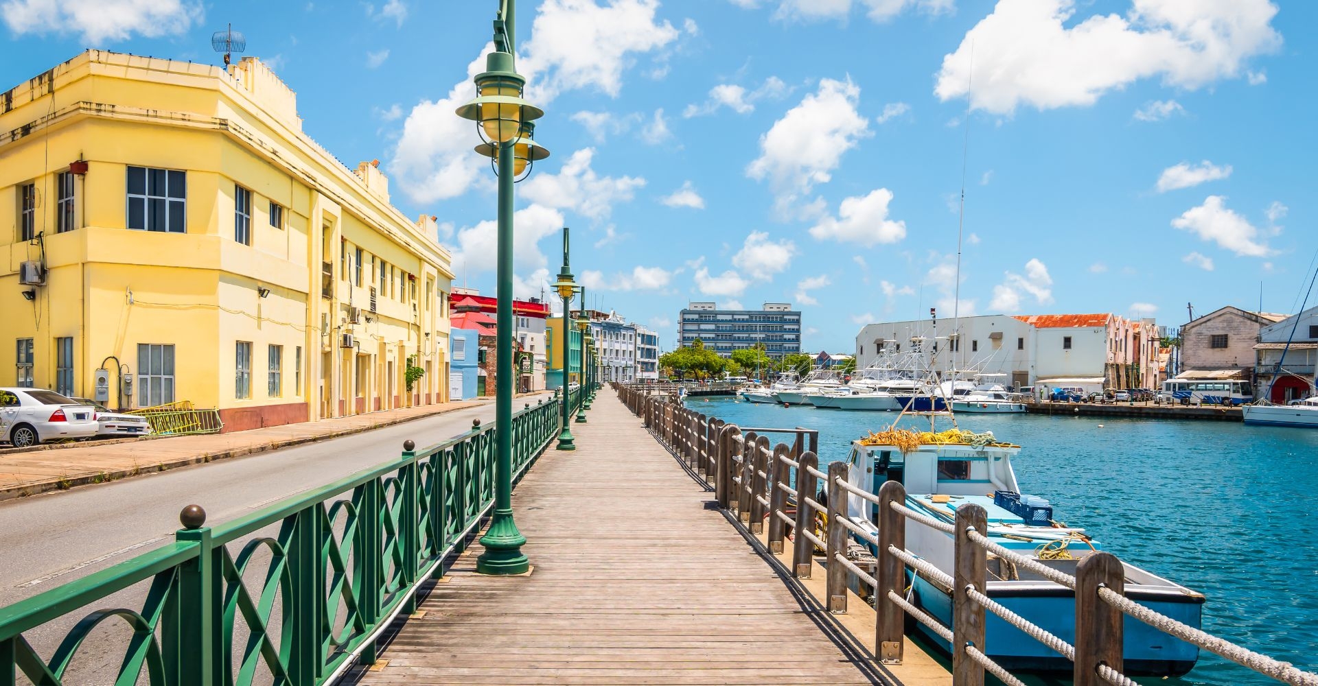 shot of a waterside walkway looking towards a bright yellow painted building