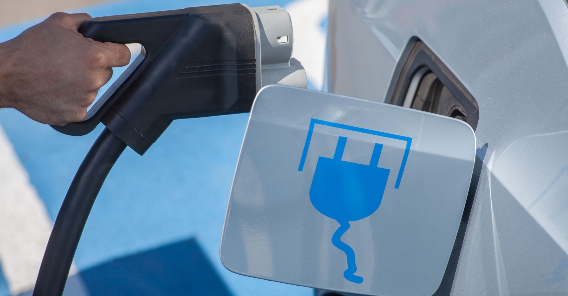 close up of a person plugging in an electric car 