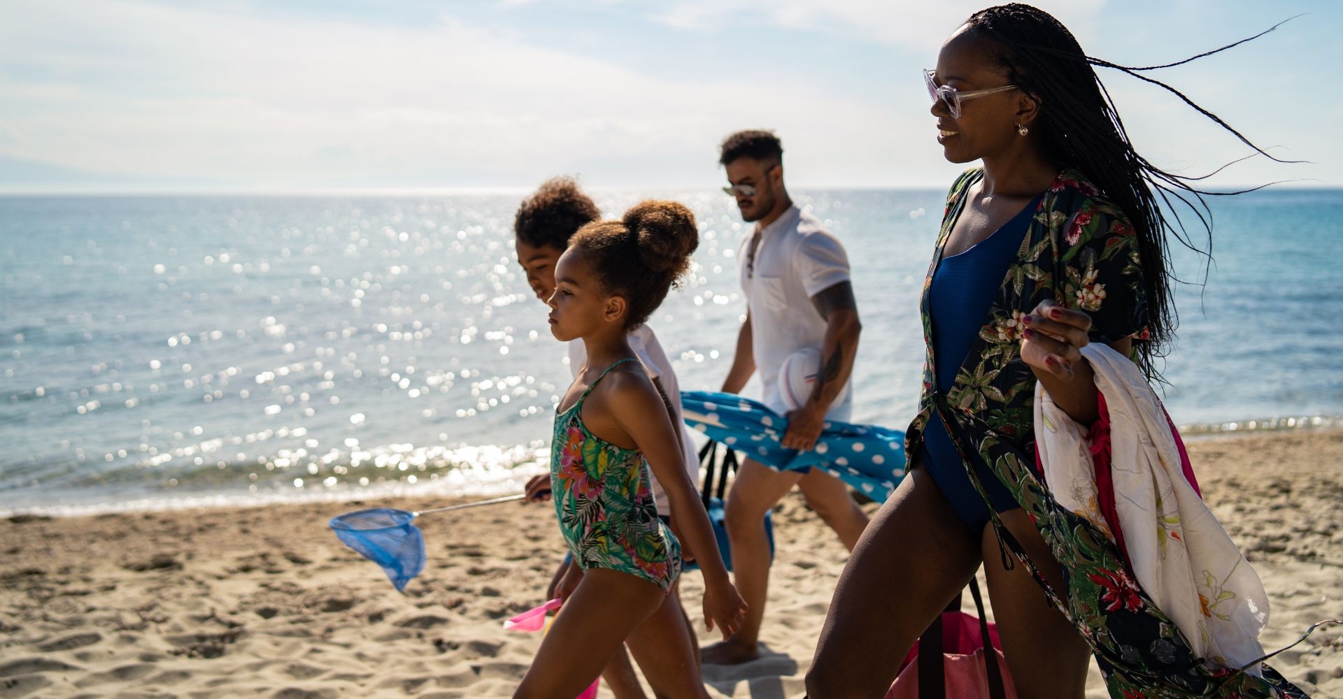 a family walking on the beach on a sunny day in Barbados 