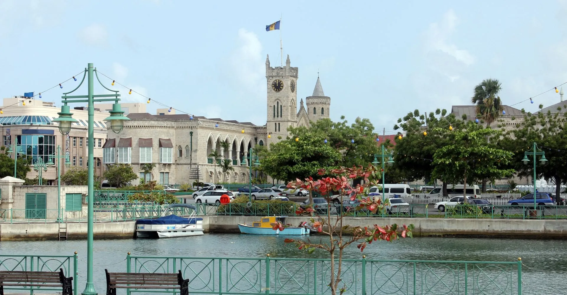  A city skyline featuring a prominent clock tower beside a flowing river under a clear blue sky