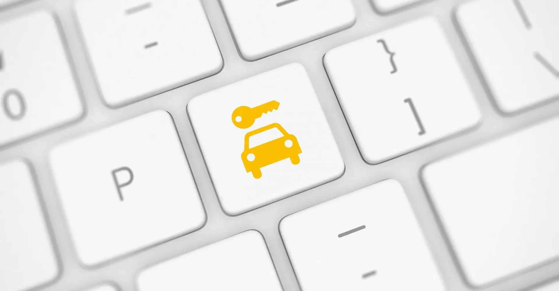 A bright yellow car key is placed on a white keyboard, highlighting its vibrant color against the neutral keys