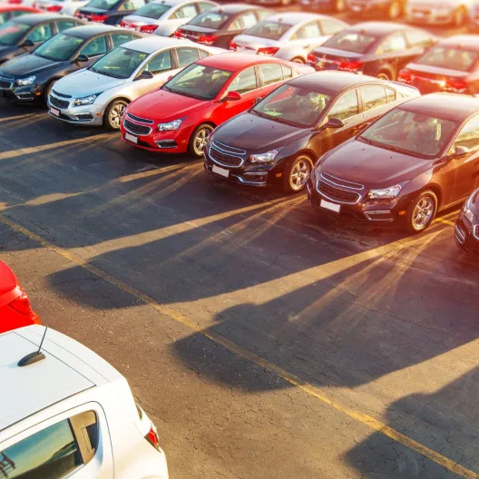 a large lot of rental cars lined up side by side