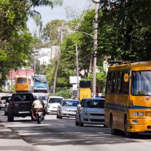 oncoming traffic including an orange bus on a roadway in Barbados 