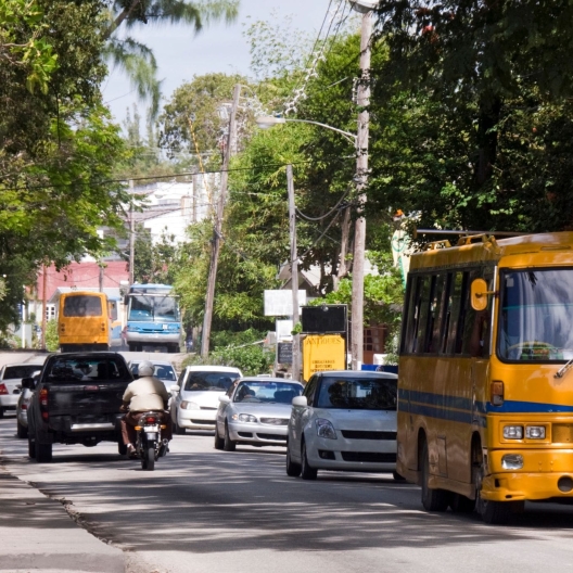 oncoming traffic including an orange bus on a roadway in Barbados 