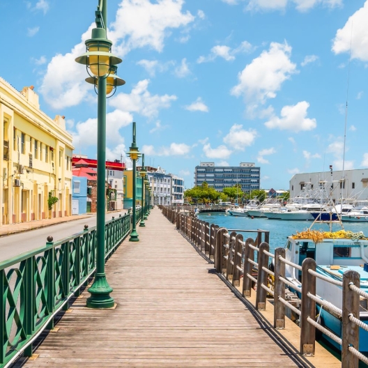 shot of a waterside walkway looking towards a bright yellow painted building