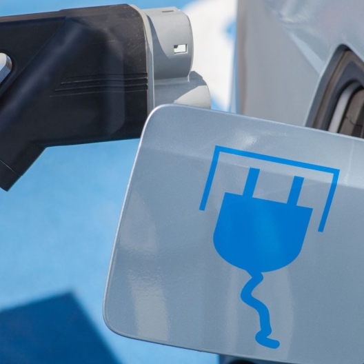 close up of a person plugging in an electric car 