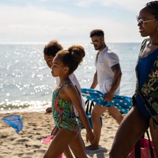 a family walking on the beach on a sunny day in Barbados 