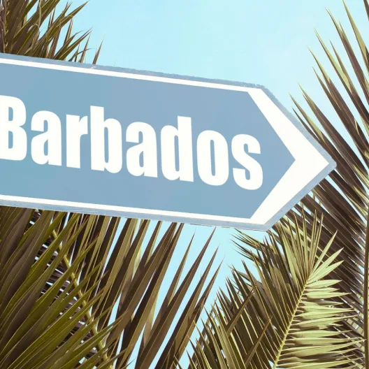 A street sign displaying the word "Barbados" against a clear blue sky