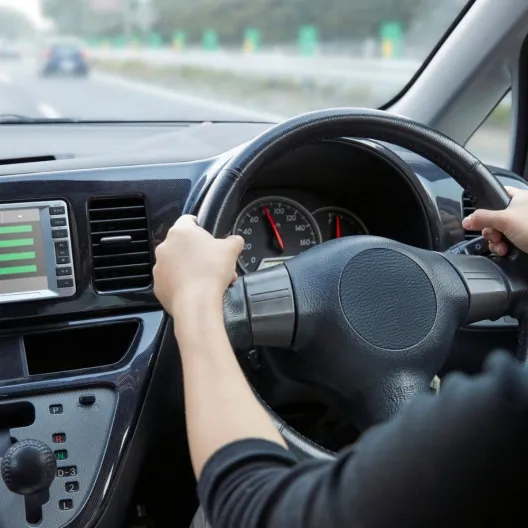A woman focused on driving a car, with a clear view of the dashboard display in front of her